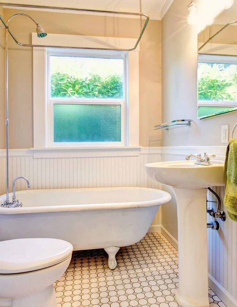 A bathroom with a tub, sink and toilet.